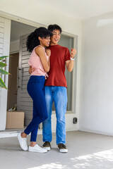 Naklejka premium Couple hugging doorway man holding key causing motion real estate icons over box marking move-in