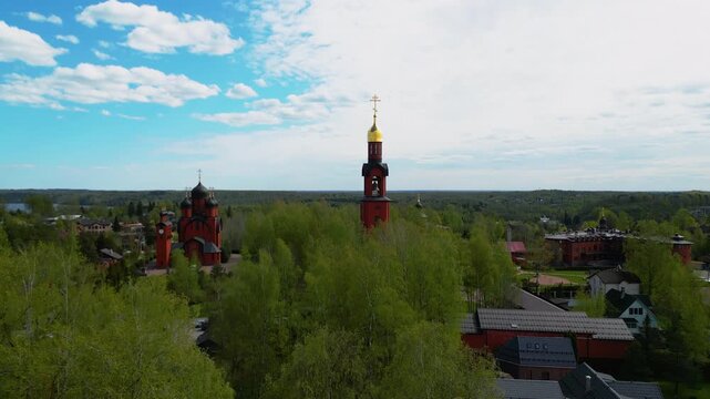 Traditional orthodox cathedral red brick church building with golden dome aerial panorama view.
