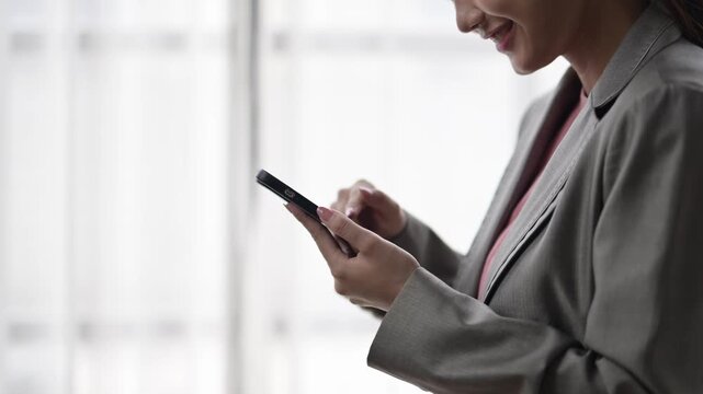 Businesswoman using smartphone near window