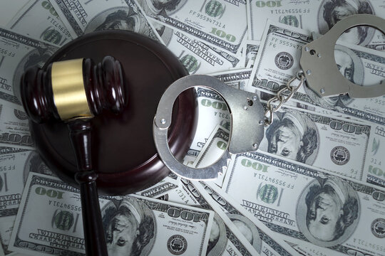 Judge Gavel and Handcuffs on US Dollar Bills Symbolizing Financial Crime