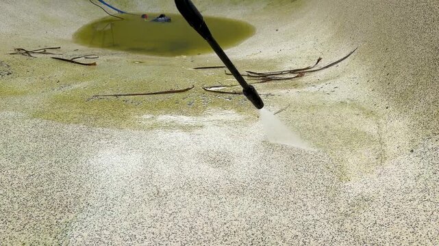 High Pressure Water Jet Cleaning Algae From Concrete Swimming Pool
