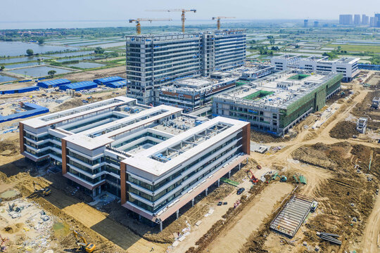 Aerial view of modern hospital complex under construction near wetlands