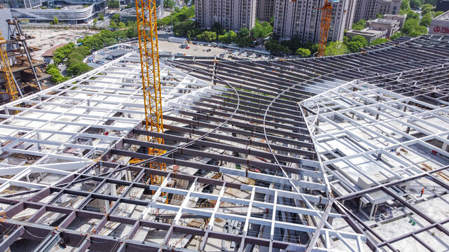 Aerial view of urban steel structure construction site with tower cranes