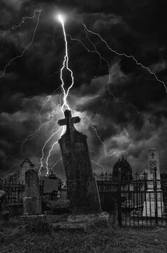 Old creepy graveyard on stormy winter day in black and white