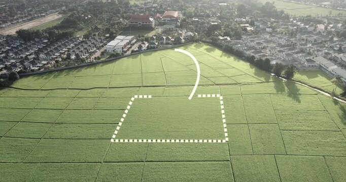 Aerial drone view of agricultural land with highlighted property boundary and GPS location pin. Green rice field surrounded by residential neighborhood, illustrating land plot mapping.