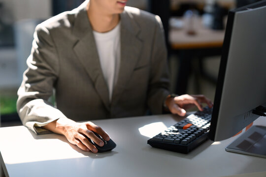 Closeup businessman working at desktop Computer with Keyboard and Mouse in Modern Office