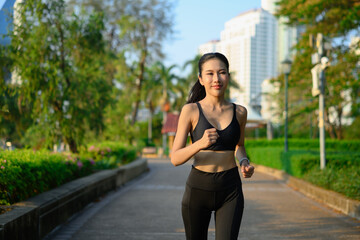 Fototapeta premium Athletic woman sport clothes running in the park. Healthy lifestyle, workout and wellness concept