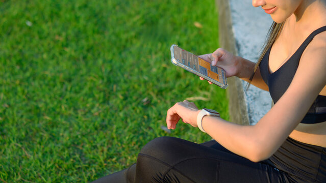 Smartphone displaying heart rate data on wrist while runner checks fitness application, showcasing modern technology in health and fitness tracking outdoors