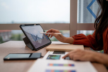 Woman working on financial data analysis using tablet © Apichat