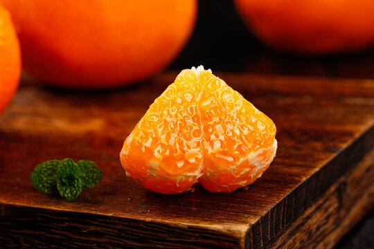Fresh Cut Tangerine Segments on Wood with Mint Garnish