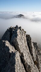 Obraz premium Mountain peak rising above foggy clouds landscape
