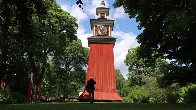 Sala Sweden A man walks to an old red wooden church bell tower on the grounds of the Sala Silver Mine.  
