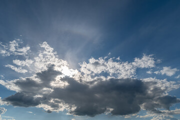 Obraz premium Sunlit sky with dramatic cloud formations and sun rays