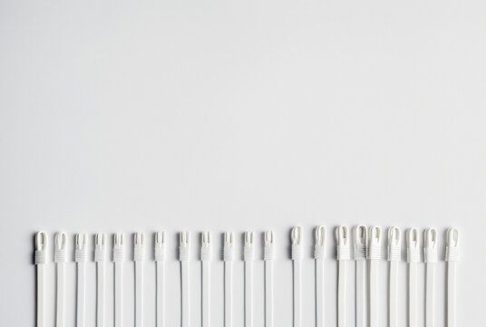 Row of white plastic security seals or fasteners on clean background with copy space