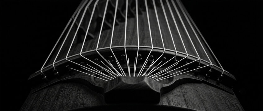 A high-contrast black and white photograph focusing solely on the geometric pattern created by the 13 parallel strings as they converge at the tailpiece of the Koto. 