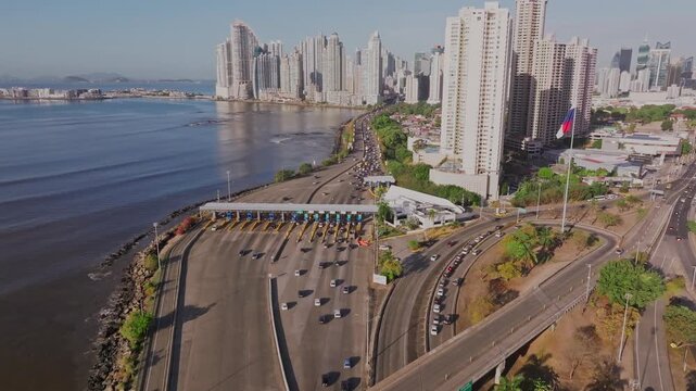 Cars heading towards Panama City on the southern corridor during a morning, aerial shot with a drone in reverse while tilting downwards