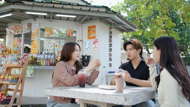 Asian University Students Talking and Drinking Beverages at Outdoor Campus Cafeteria