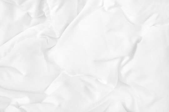 Close up top view of white bedding sheet and wrinkle messy blanket in bedroom after wake up in the morning.