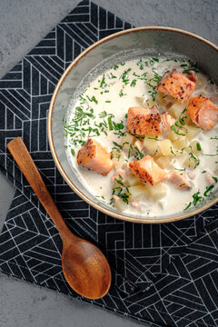 Creamy Finnish lohikeitto soup featuring seared salmon pieces, potatoes in rich broth and dill topping. Authentic Scandinavian salmon chowder, wholesome restaurant-style seafood dish, top view