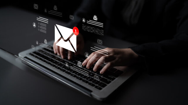 Close-up of hands typing on a laptop with email notifications displayed in a digital interface, representing online communication and technology in modern business environments. Cyphers
