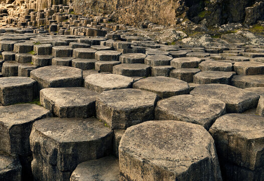 Natural basalt columns of the giant's causeway in northern ireland, featuring unique hexagonal stone formations and rugged volcanic rock textures