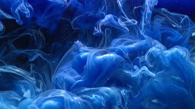 Blue ink swirls gracefully through clear water in dark space