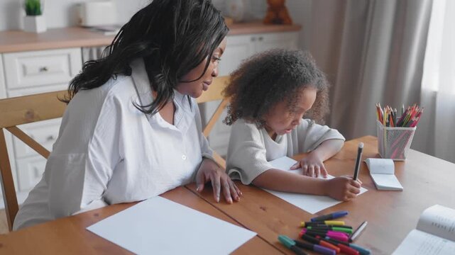 Tutor and pupil girl exercising at home, practice of educating children at home. African american family, black woman and schoolgirl doing homework in apartment interior, studying and education