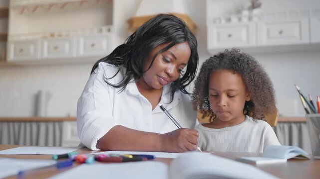 Portrait of smart little girl doing homework and tutor or mother controlling. African american woman helping to, practicing spelling and orthography, home education, tutoring for kids