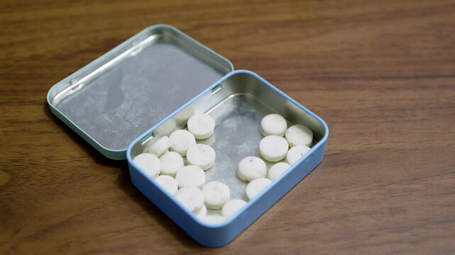 Hand Taking a Refreshing Mint Candy from Tin Box &ndash; Everyday Consumer