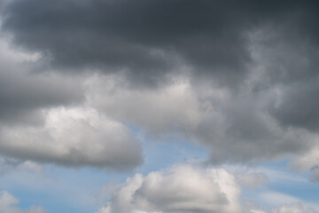 Obraz premium Stormy sky imagery. Menacing storm clouds herald approaching thunderstorm. Gloomy atmospheric scene featuring thick storm clouds and sporadic luminous flashes in sky