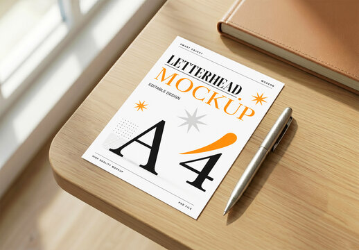 A4 Letterhead Mockup on Wooden Desk with Pen and Notebook