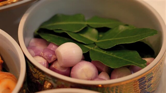 Fresh Shallots and Kaffir Lime Leaves in Traditional Thai Benjarong Bowl Close Up Cooking Ingredient
