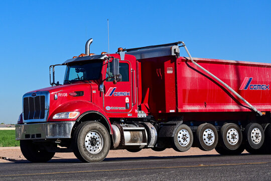 Transfer dump truck traveling along a roadway, representing material hauling, construction support, and industrial transportation operations