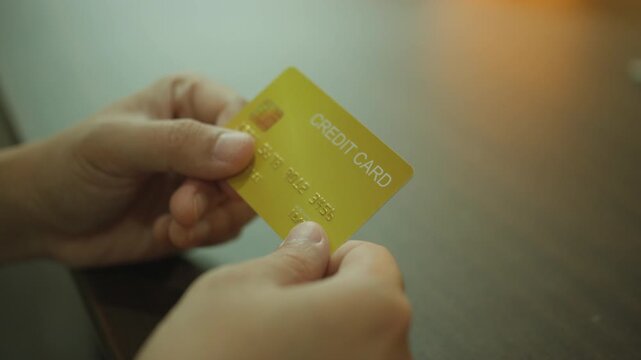 Closeup of Customer Hands Holding Golden Credit Card, Verifying Financial Credentials for Online Shopping. business idea concept.