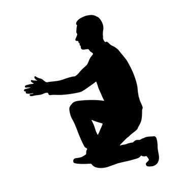 Silhouette of a man kneeling and reaching forward with open hands