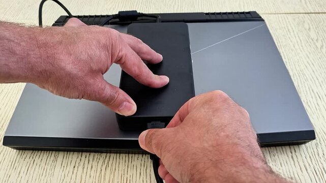 External SSD connected to a laptop through a USB adapter, showcasing portable storage, fast data transfer, modern computing technology, file management, and digital workflow