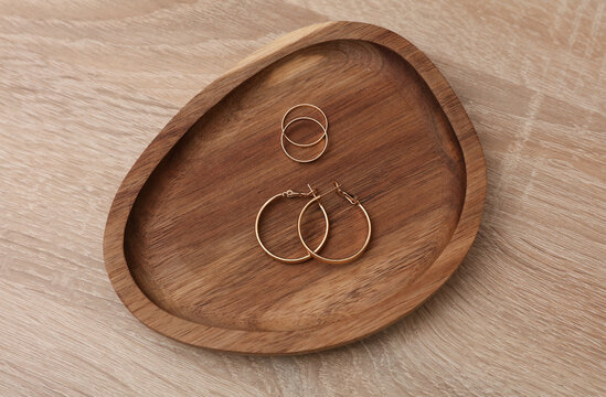 Gold earrings and rings in a tray on the table