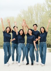 Obraz premium Group of young East Asian friends cheering together in matching blue outfits for lifestyle , community advertising and social connection marketing