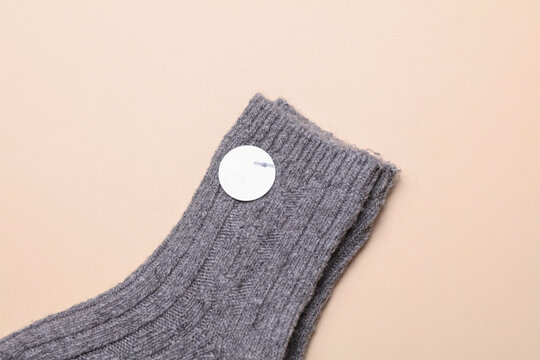 Socks with white blank stickers on a beige background