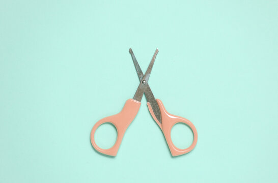 Scissors for baby care on pink background. Top view