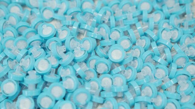 Scientific footage showing use of blue PTFE syringe filters for filtering liquid samples prior to LC and HPLC analysis. Analytical laboratory workflow, research equipment, chemistry sample