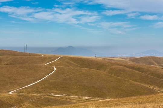 View of winding road and peaks of Mount Beshtau from Mount Bolshoe Sedlo