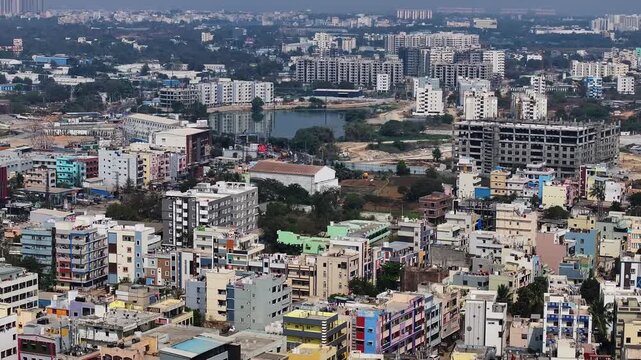 Residential buildings with Apartments, Sri Sai Pooja Theatre, under construction building and kattamysamma lake at suraram, hyderabad, telangana, india. day time, semi circle shot, drone shot, 4k.