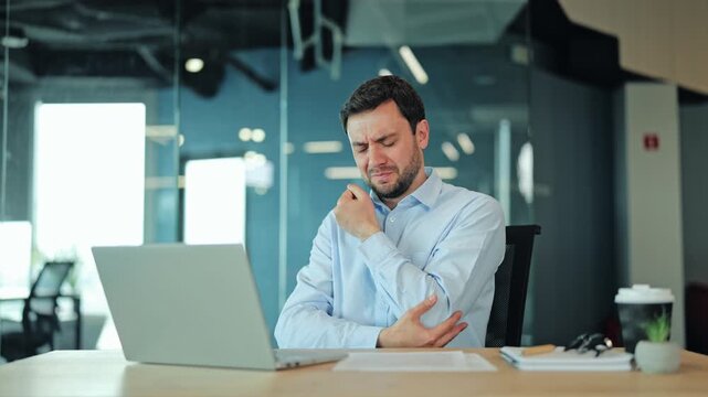 Close up of corporate manager or IT specialist suffering from elbow ache, tendonitis or arm inflammation at laptop. Tired employee or freelance designer feeling severe joint pain during office work