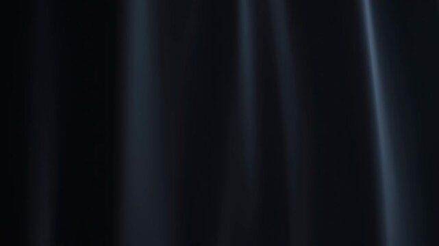 Elegant black fabric draping softly in the light. Ideal for fashion, design, and artistic presentations