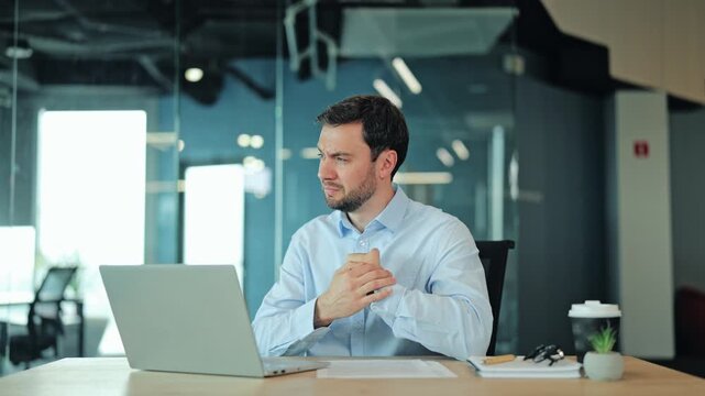 Corporate manager or IT specialist suffering from wrist ache, sprain or joint inflammation at laptop. Tired employee or freelance designer feeling severe hand pain during professional office work