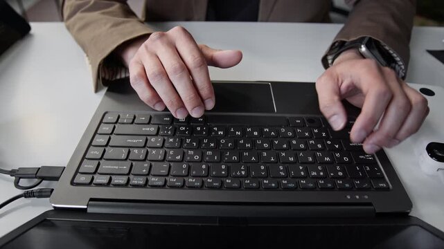 Close-up shot of unknown programmer typing on laptop keyboard, writing code in office. Footage for software development, IT startup, and online technology education marketing campaigns