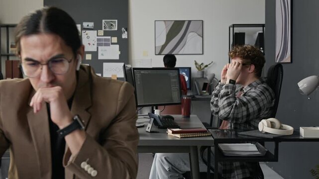 Rack focus shot of diverse young programmers working on computers in modern IT office. Footage for promoting software development services, tech startups
