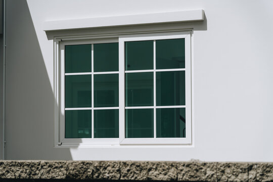 White sliding window glass window window frame modern window exterior wall sunlight shadow home exterior residential building architectural detail clean design