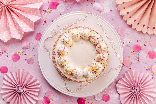 Delicious Cream cake for birthday party with pink paper decorations